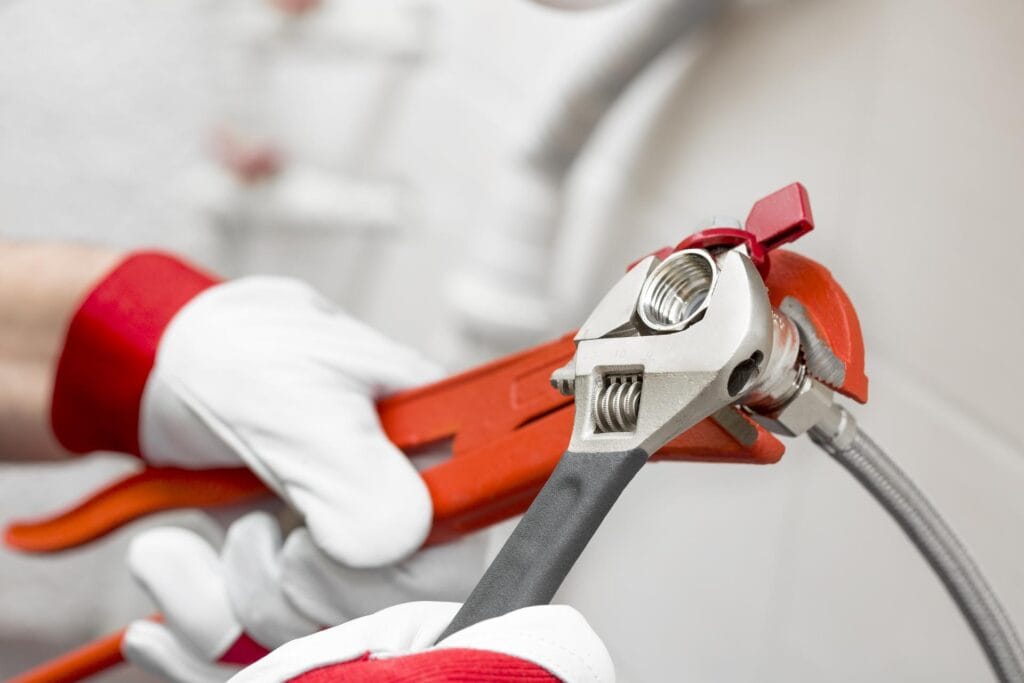 Plumber holding pipe wrenches for an emergency repair in Crestview