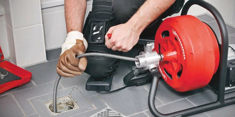 Plumber using a drain-cleaning machine in Crestview