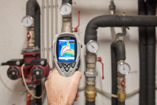 Plumber using a thermal imaging camera to inspect pipes in Crestview