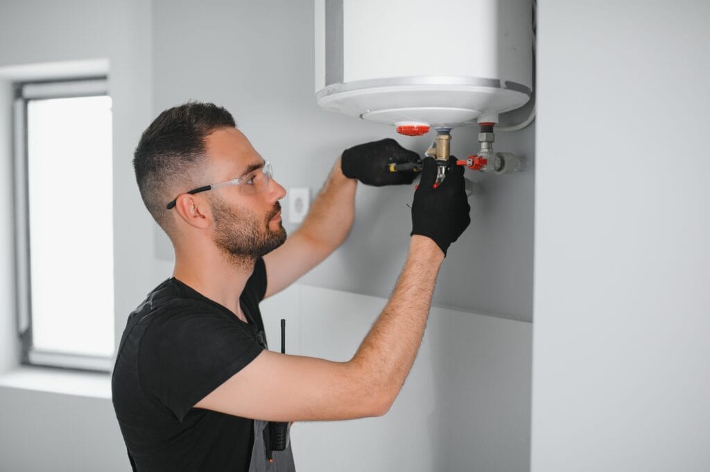 Technician performing water heater maintenance in Crestview