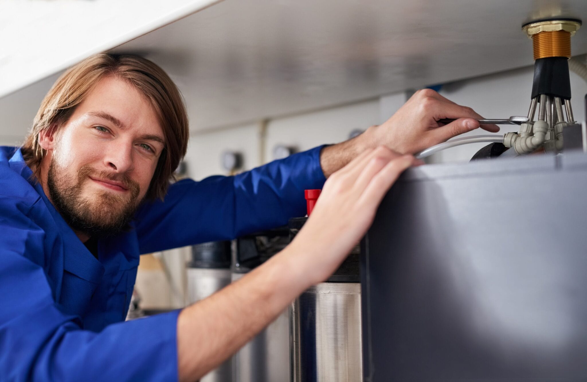 Technician servicing a residential water heater tank in Crestview